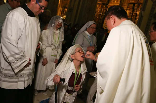 Una católica de Taiwán se arrodilla para recibir la Eucaristía durante la misa celebrada en la iglesia de San Agustín. Crédito: Eduardo Berdejo / EWTN News.