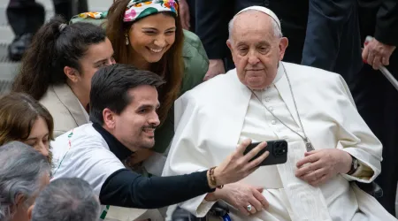 El Papa Francisco se toma una foto junto a varios jóvenes durante una audiencia.