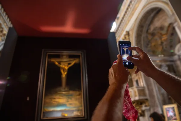 Un visitante toma una foto del Cristo de Dalí en la Iglesia San Marcello al Corso, en el centro de Roma. Crédito: Daniel Ibáñez / EWTN News
