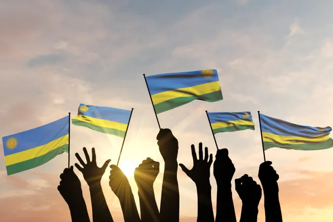 Silueta de manos levantada ondeando bandera de Ruanda