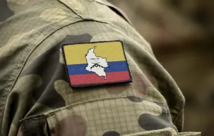 Bandera de las Fuerzas Armadas Revolucionarias de Colombia (FARC) con uniforme militar. Crédito: Shutterstock. 