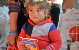 Una niña siria sostiene un ejemplar de la Biblia. Foto: Ayuda a la Iglesia Necesitada 