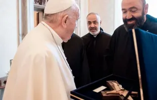 El abad general de la Orden Maronita Mariamita, Pierre Najm, entrega la cruz al Papa Francisco. Créditos: Vatican Media 