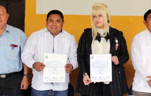 El alcalde de Oxkutzcab, Raúl Romero Chel, sostiene una copia del supuesto convenio junto a Harriet Turner. Foto: Facebook / Ayuntamiento de Oxkutzcab. 