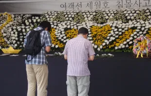 En Seúl dos personas dejan flores ante el memorial del ferry de Sewol (foto Walter Sánchez Silva / ACI Prensa) 