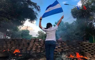 Una mujer con la bandera de Nicaragua en una barricada durante las protestas de abril de 2018. Foto: Voice of America / Dominio público. 