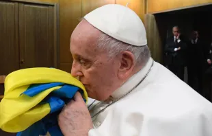 El Papa Francisco sostiene una bandera de Ucrania durante la proyección de un documental sobre la guerra. Crédito: Vatican News 