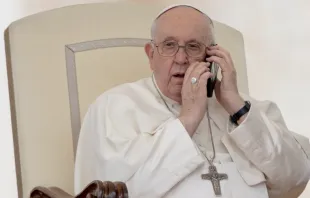 El Papa Francisco atiende una llamada telefónica durante la Audiencia General. Crédito: Daniel Ibáñez/ACI Prensa 