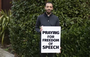P. Sean Gough con su letrero que dice "rezo por la libertad de expresión". Crédito: ADF International 