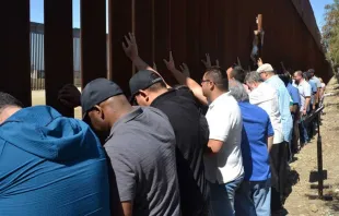 Sacerdotes scalabrinianos rezan ante muro que separa México y Estados Unidos. Crédito: Cortesía Casa del Migrante en Tijuana. 