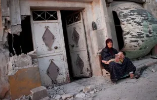 Mujer siria se sienta con su nieto frente a un edificio dañado de la aldea de Treimsa (Siria) / Crédito: Fondo Andaluz de Municipios para la Solidaridad Internacional (CC BY-NC-ND 2.0) 