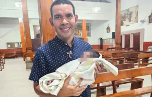 El P. Alejandro Enrique Ruiz Puerto junto a la bebé abandonada. Crédito: Cortesía