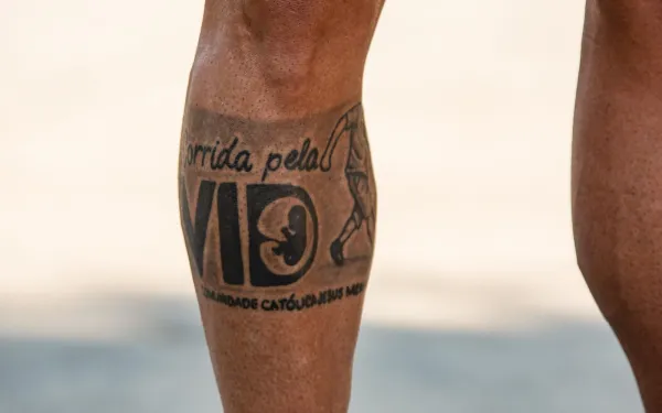 Tatuaje que Alexandre se hizo en la pierna, "Carrera por la Vida - Comunidad Católica Jesús Menino". Crédito: Davi Corrêa / ACI Digital.