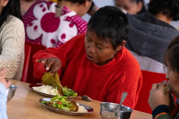 Una mujer almuerza en el albergue de la Asociación de las Bienaventuranzas. Crédito: Asociación de las Bienaventuranzas.