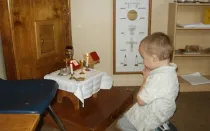 Un niño reza ante el altar en el atrio de la Catequesis del Buen Pastor.