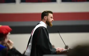 La estrella de la NFL, Harrison Butker, habla con los graduados universitarios en su discurso de graduación en Benedictine College el sábado 11 de mayo de 2024. Crédito: Benedictine College