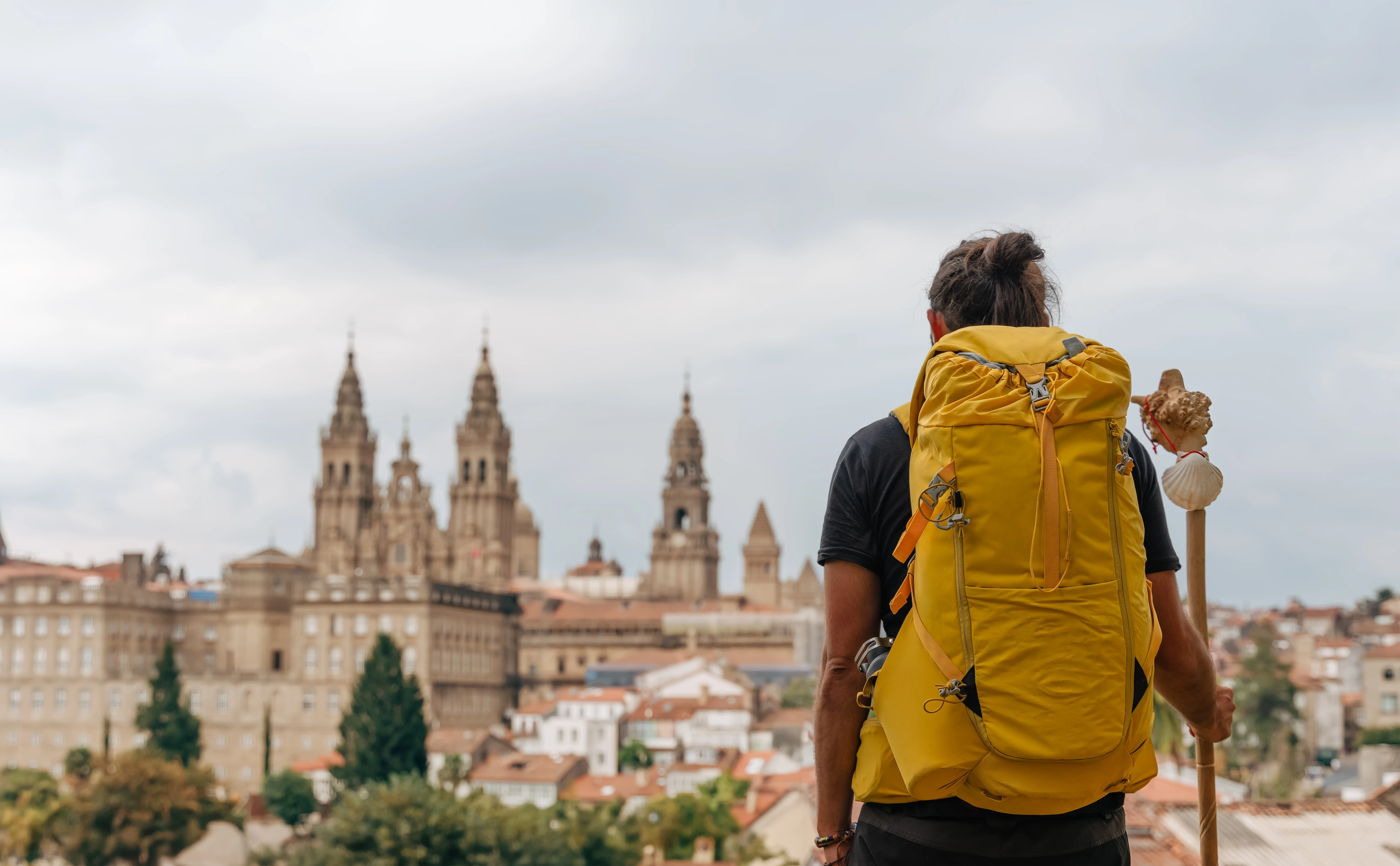 Joven peregrino termina el Camino de Santiago disfrutando de la catedral y del paisaje del casco antiguo de Santiago de Compostela en Galicia, España.?w=200&h=150