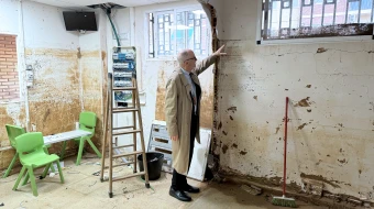 El Cardenal Michael Czerny señala la altura a la que llegó el agua en las inundaciones en Valencia (España).