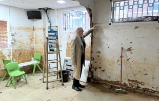 El Cardenal Michael Czerny señala la altura a la que llegó el agua en las inundaciones en Valencia (España). Crédito: Departamento de Comunicación de la Archidiócesis de Valencia.