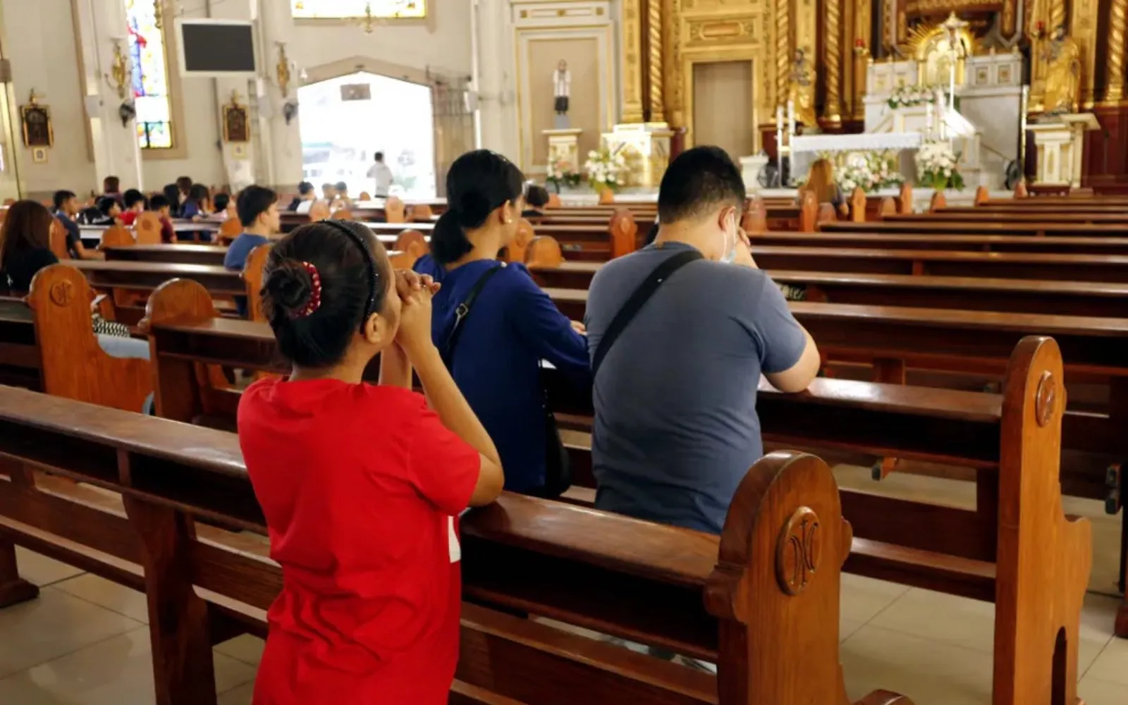 Hombres y mujeres católicos se arrodillan y rezan dentro de la Catedral de Antipolo en Filipinas.?w=200&h=150