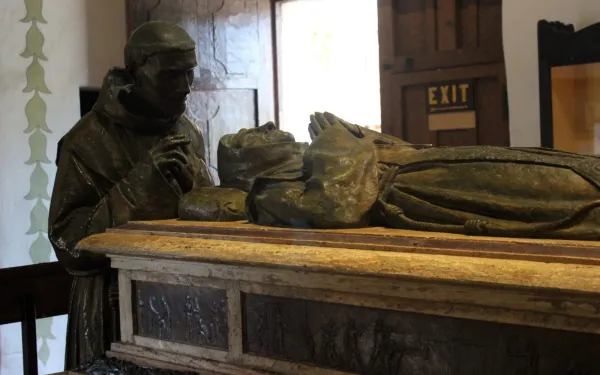 Image at the San Carlos Borromeo mission, in Carmel-by-the-Sea (California), of Father Juan Crespí, who died before Saint Junípero Serra, praying before the body of the saint.  Credit: Miguel Hermoso Cuesta (CC BY-SA 4.0).