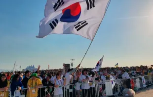 Peregrinos de Corea del Sur ondean una bandera en la Misa con el Papa Francisco para la clausura de la Jornada Mundial de la Juventud 2023, en Lisboa, el 6 de agosto de 2023. Crédito: Hannah Brockhaus/CNA