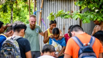 Equipo misionero rezando en pueblo guatemalteco.