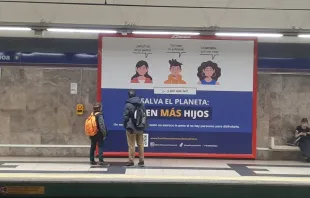 Un padre y su hijo ante la campaña que anima a aumentar la familia. Crédito: Asociación de Familias Numerosas de Madrid.