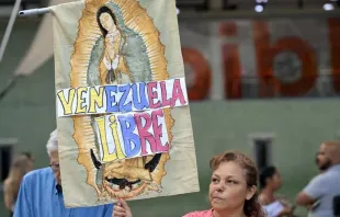 Una mujer sostiene una imagen de la Virgen de Guadalupe con las palabras “Venezuela Libre” durante una vigilia convocada por la oposición para exigir la libertad de los presos políticos detenidos durante las protestas tras la impugnada reelección del presidente venezolano, Nicolás Maduro, en Caracas, el 8 de agosto. Crédito: Yuri Cortez / Getty