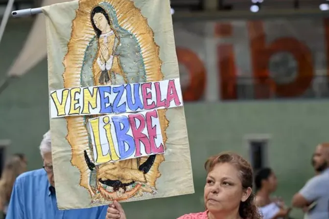 Una mujer sostiene una imagen de la Virgen de Guadalupe con las palabras “Venezuela Libre” durante una vigilia en Caracas