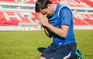 Imagen referencial de un futbolista rezando Crédito: Freepik