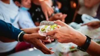 Voluntarios otorgando alimentos a personas de escasos recursos.