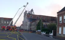 Los bomberos trabajan para apagar el fuego en la iglesia de la Inmaculada Concepción en Saint Omer.