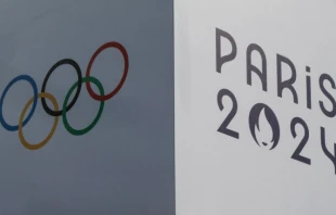 Una pancarta lleva los signos de los Juegos Olímpicos de París 2024 y los anillos olímpicos, en el Trocadero en París, el 14 de julio de 2024. Crédito: Stefano Rellandini/AFP vía Getty Images.