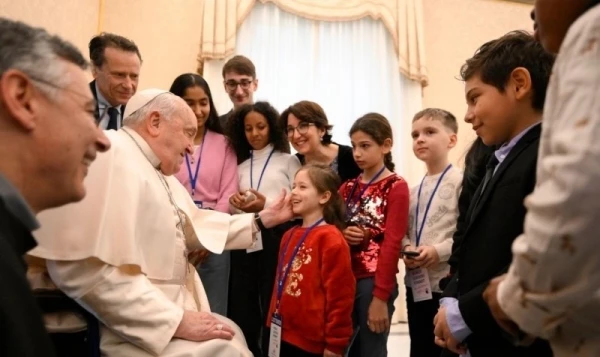 Pope Francis greets a group of children before his first intervention. Credit: Vatican average