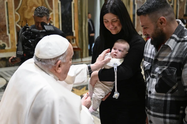 Pope Francis bless a newborn at the audience. Credit: Vatican average