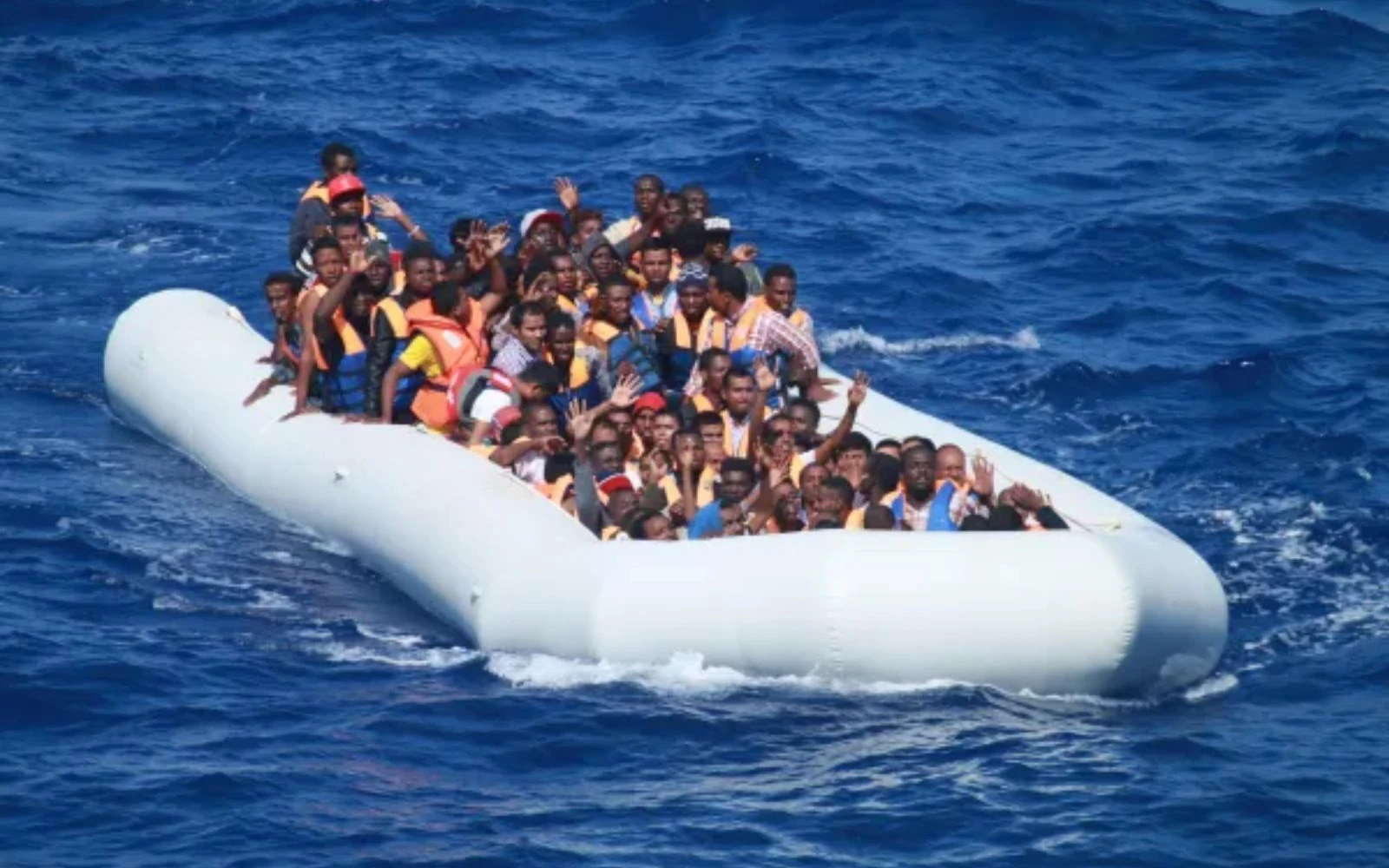 Los migrantes a bordo de un barco inflable en el mar Mediterráneo se acercan a un destructor de los EEUU.?w=200&h=150