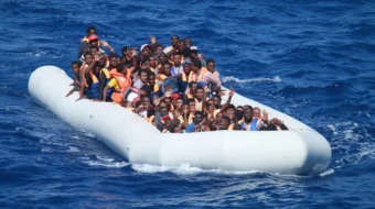 Los migrantes a bordo de un barco inflable en el mar Mediterráneo se acercan a un destructor de los EEUU.