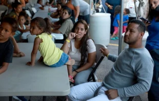 Dainelys Soto, Génesis Contreras y Daniel Soto, quienes llegaron de Venezuela luego de cruzar la frontera de Estados Unidos desde México, esperan la cena en un hotel proporcionado por Annunciation House el 22 de septiembre de 2022 en El Paso, Texas. Crédito: Joe Raedle/Getty Images.