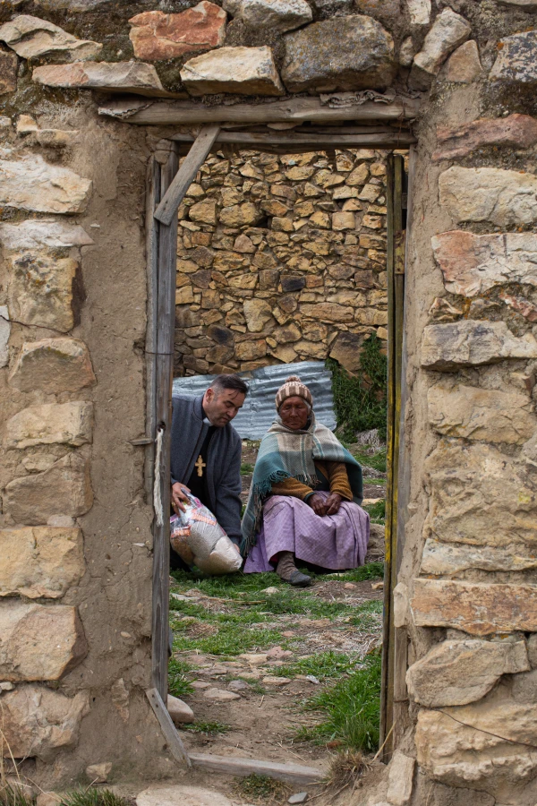 Mons. Giovanni Cefai visitando a una mujer campesina en Huancané. Crédito: Cortesía de Prelatura de Huancané