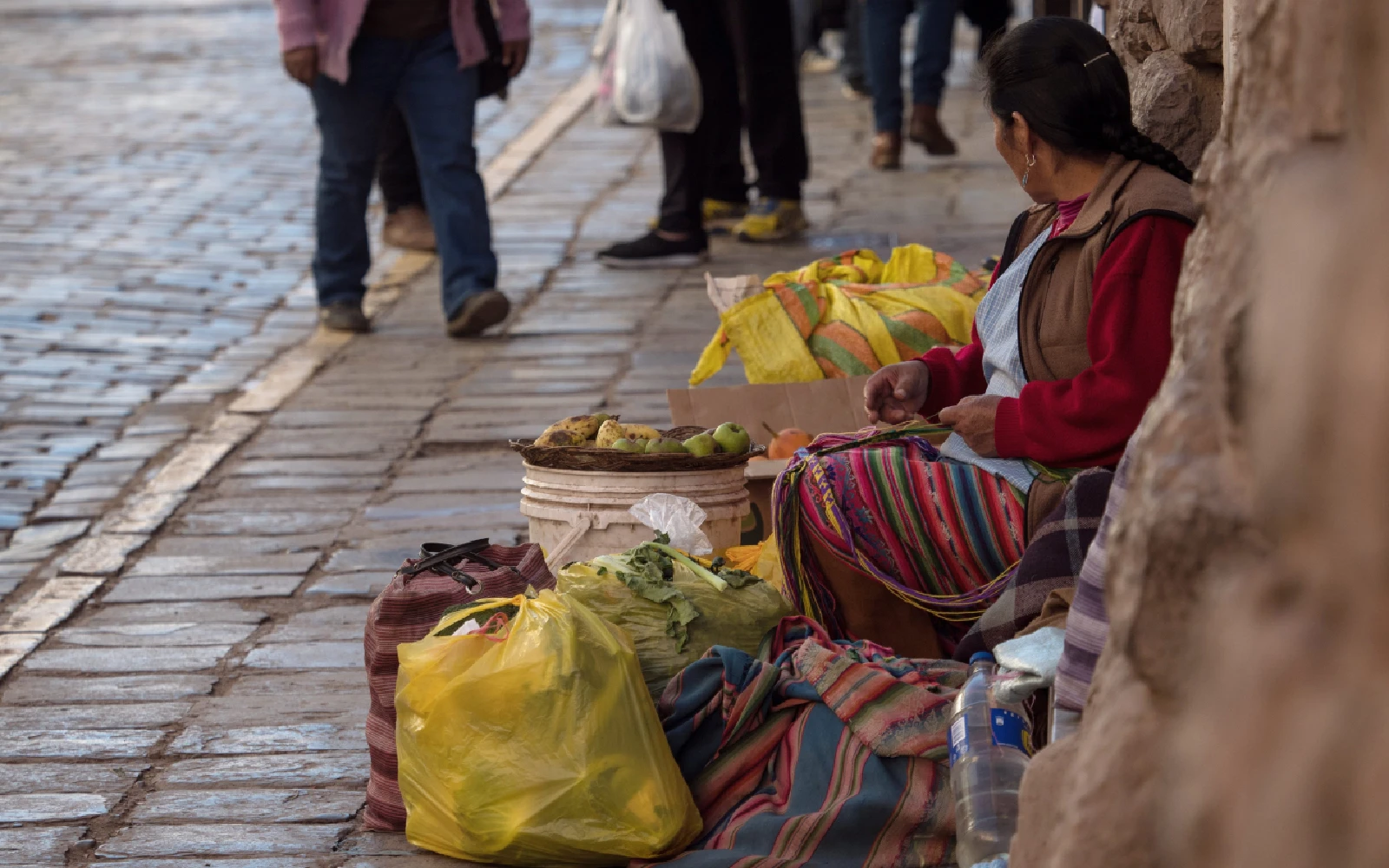 Mujer indígena con traje tradicional vendiendo frutas y verduras en las calles de Cusco, Perú.?w=200&h=150