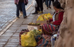 Mujer indígena con traje tradicional vendiendo frutas y verduras en las calles de Cusco, Perú. Crédito: Shutterstock