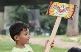 Un niño sostiene un cartel con una imagen del Espíritu Santo. Crédito: Juan Pablo Arias / Cathopic