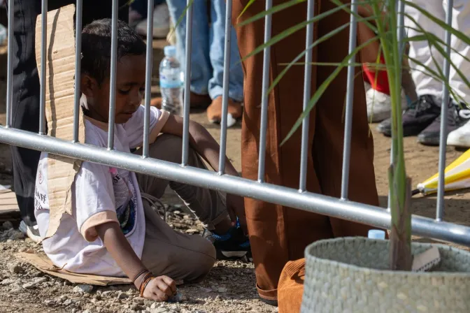 Un niño sentado en cartones presencia la Misa del Papa Francisco de este 10 de septiembre en Timor Oriental