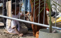 Un niño sentado en cartones presencia la Misa del Papa Francisco de este 10 de septiembre en Timor Oriental