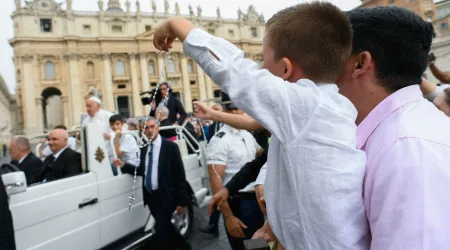 Imagen referencial de un niño sujetando un Rosario mientras saluda al Papa Francisco