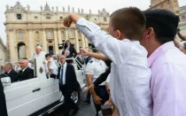 Imagen referencial de un niño sujetando un Rosario mientras saluda al Papa Francisco