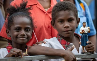 Dos niños, uno de ellos con una estatua del beato Pedro To Rot, esperan la visita del Papa Francisco en la Escuela Secundaria Técnica de Cáritas en Port Moresby (Papúa Nueva Guinea), 7 de septiembre de 2024. Crédito: Daniel Ibáñez / EWTN News.