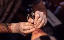 Foto referencial de una persona haciendo un tatuaje.