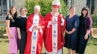 El P. John Morrill y el obispo de East Anglia (al centro) con las cuatro hijos del nuevo sacerdote a los costados.